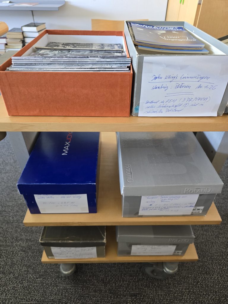 Bücherwagen mit Schuhkartons. die mit Heftromanen befüllt sind.